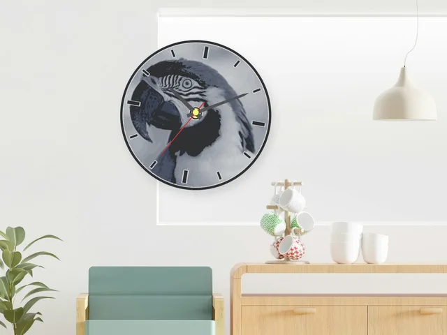 Round wall clock with a parrot photo printed in greys and black hour lines, hanging on a white wall